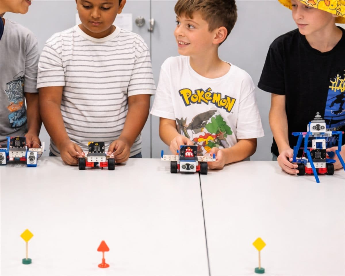 Kids building and racing the rovers they coded at a ThinkerLab Young Maker MasterClass in Caroline Springs